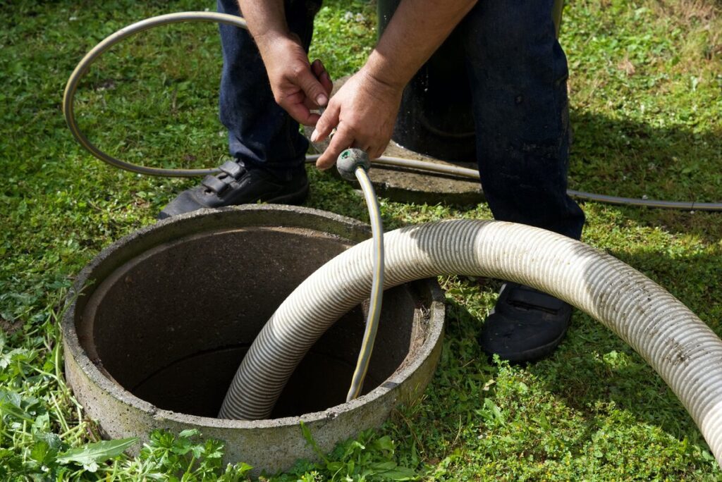 A professional attaching a plug to a septic pump